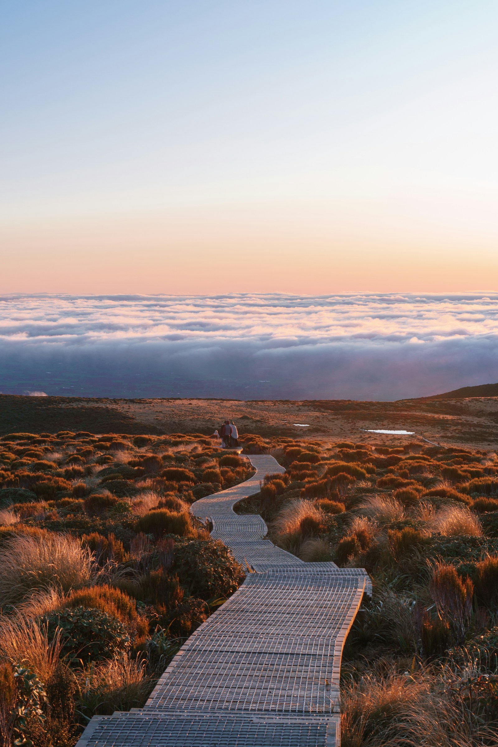 Een slingerend wandelpad door het berglandschap bij zonsopkomst.